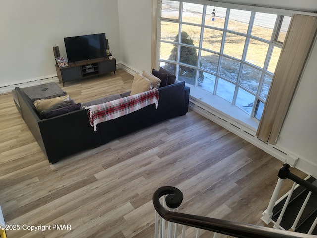 living room with a baseboard heating unit and wood finished floors