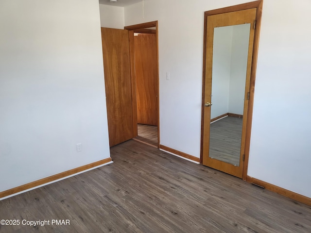 empty room with baseboards and wood finished floors