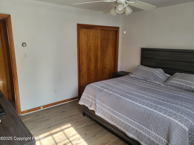 bedroom with a ceiling fan, baseboards, and wood finished floors