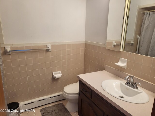 bathroom with toilet, a shower with curtain, a baseboard radiator, vanity, and tile walls