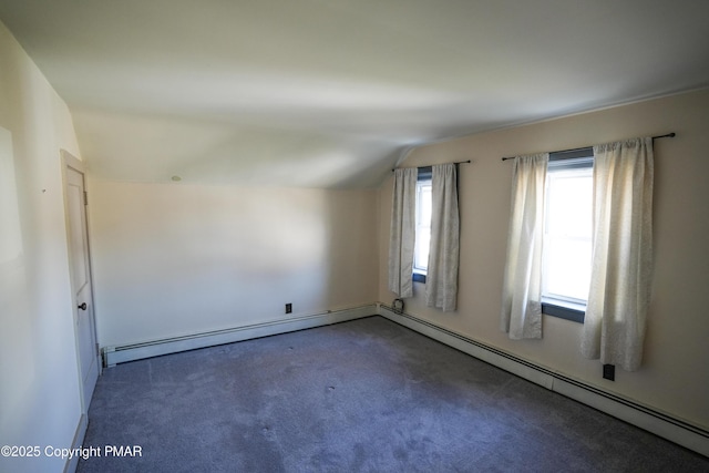 carpeted empty room featuring vaulted ceiling and baseboard heating