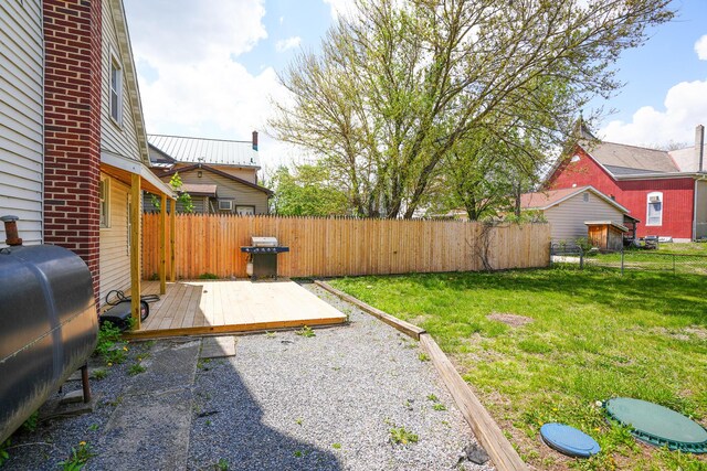 rear view of property with a lawn, a chimney, heating fuel, and a fenced backyard