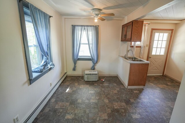 interior space featuring a sink, a ceiling fan, baseboards, stone finish flooring, and a baseboard radiator