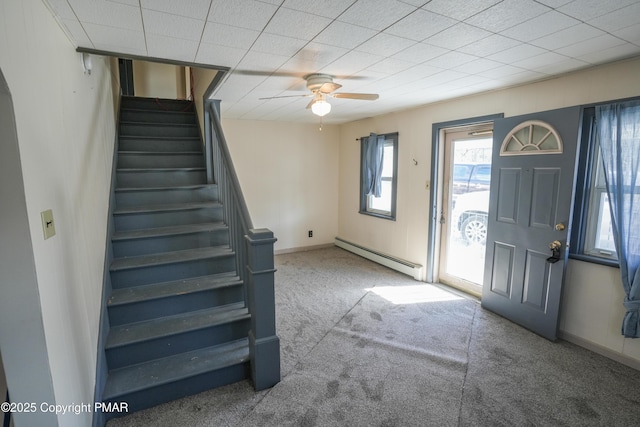 carpeted foyer with ceiling fan and a baseboard heating unit