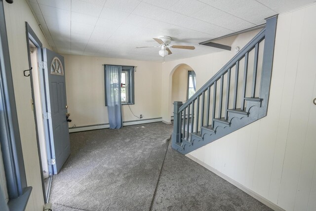 entrance foyer featuring ceiling fan, baseboards, a baseboard heating unit, carpet flooring, and stairs