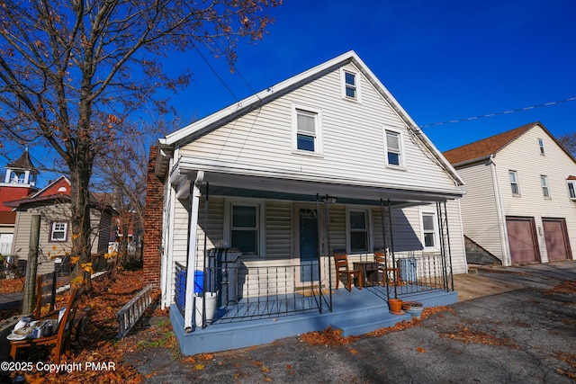 bungalow-style home featuring a garage and covered porch