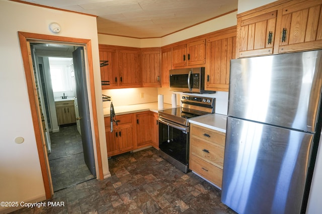 kitchen with ornamental molding, stainless steel appliances, and sink