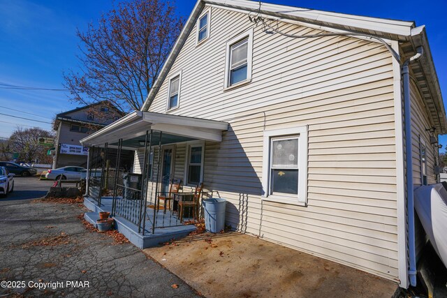 rear view of property with covered porch