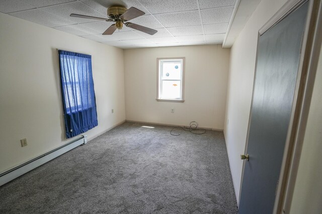 spare room with carpet floors, a baseboard radiator, a ceiling fan, and a drop ceiling
