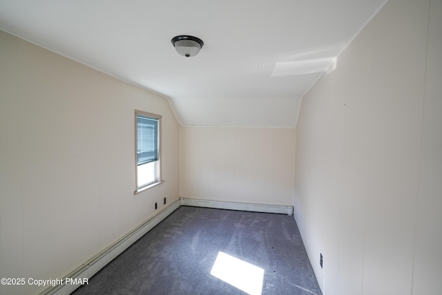 additional living space featuring dark colored carpet, a baseboard radiator, and lofted ceiling