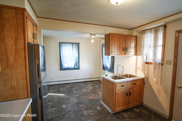 kitchen featuring sink, stainless steel fridge, ceiling fan, baseboard heating, and crown molding