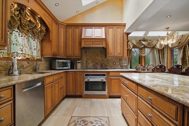 298 Overlook Way, Tannersville, PA 18372 - kitchen with appliances with stainless steel finishes, a skylight, brown cabinets, light tile patterned floors, and vaulted ceiling