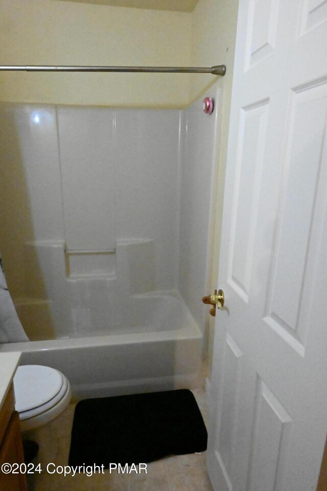 full bathroom featuring washtub / shower combination, toilet, tile patterned flooring, and vanity