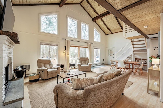 73 Big Bass Dr, Gouldsboro, PA 18424 - living area with stairs, wood ceiling, a brick fireplace, light wood-style flooring, and beamed ceiling