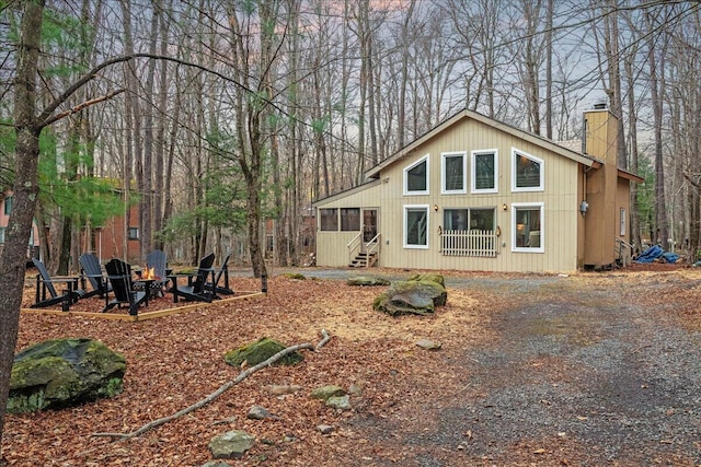 73 Big Bass Dr, Gouldsboro, PA 18424 - back of property with a sunroom, a fire pit, and a chimney