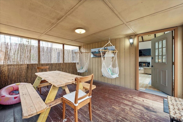 73 Big Bass Dr, Gouldsboro, PA 18424 - dining room with wood-type flooring, a warm lit fireplace, plenty of natural light, and wooden walls
