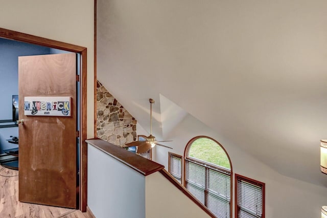 hallway featuring an upstairs landing and wood finished floors
