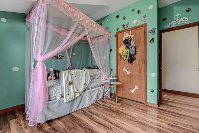 bedroom with wood finished floors and baseboards