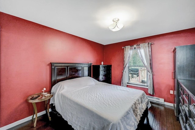 bedroom featuring dark wood-style floors, baseboard heating, and baseboards