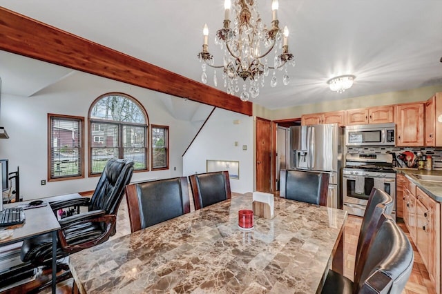 dining space with lofted ceiling with beams and a notable chandelier