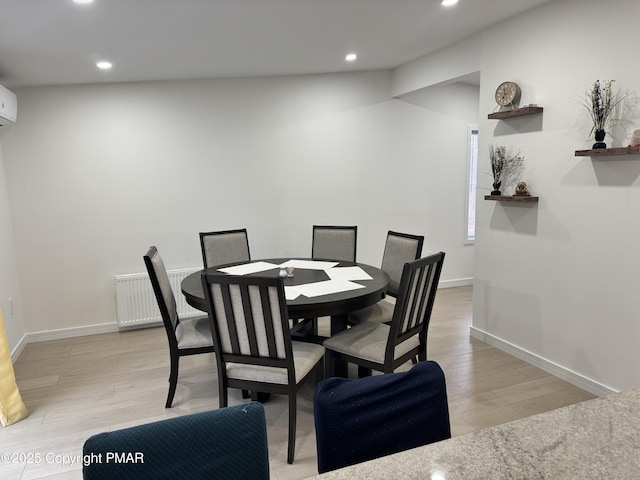 dining space with baseboards, radiator heating unit, light wood-type flooring, and recessed lighting