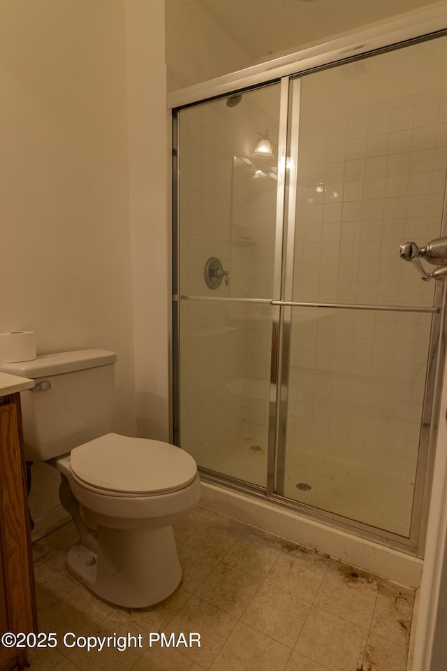 bathroom featuring vanity, tile patterned flooring, a shower stall, and toilet