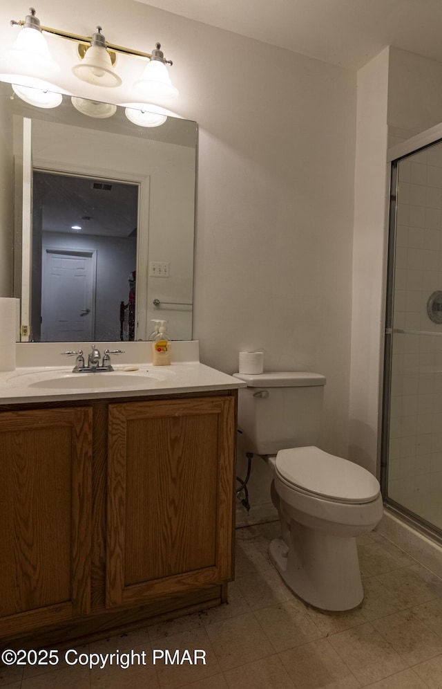 full bathroom featuring toilet, a stall shower, visible vents, and vanity