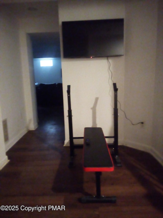 exercise area featuring baseboards and wood finished floors