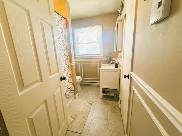 bathroom featuring vanity, toilet, a shower with curtain, and baseboard heating