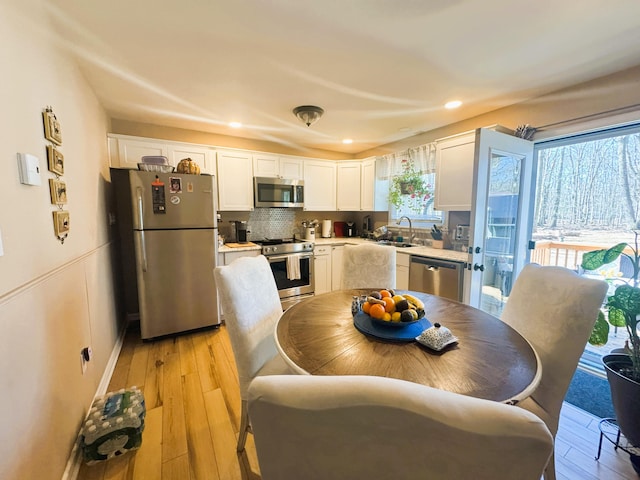 dining room with recessed lighting and light wood finished floors