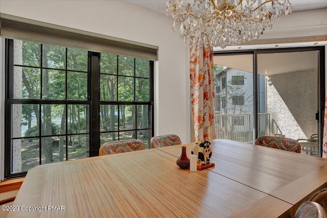 dining area with plenty of natural light and a notable chandelier