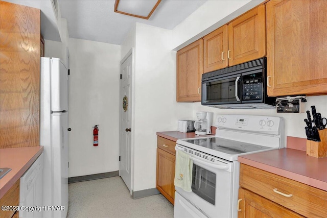 kitchen featuring white appliances, light countertops, and baseboards