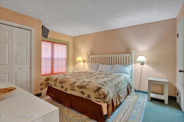 carpeted bedroom with a closet, baseboards, and a textured ceiling