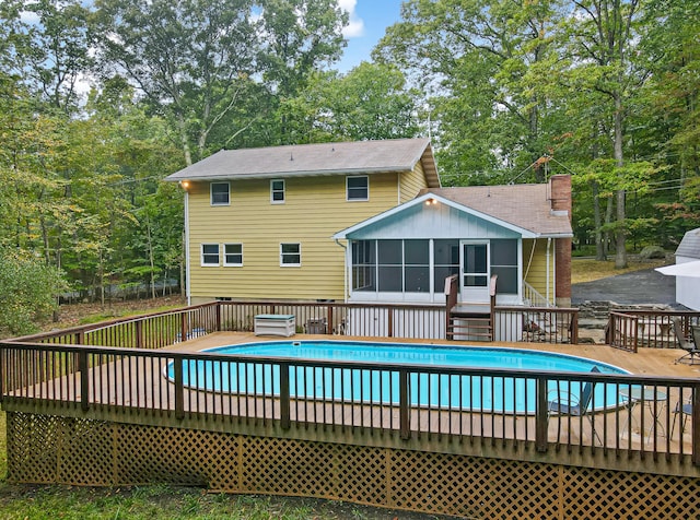 view of pool featuring a deck, a fenced in pool, and a sunroom