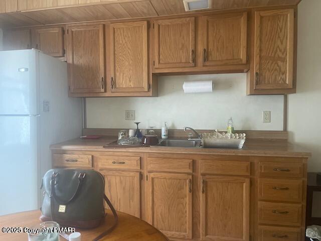 kitchen featuring light countertops, freestanding refrigerator, and visible vents