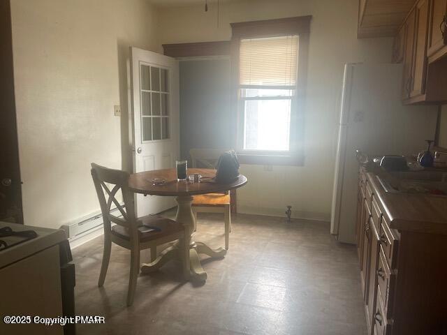 dining space with light floors and baseboards