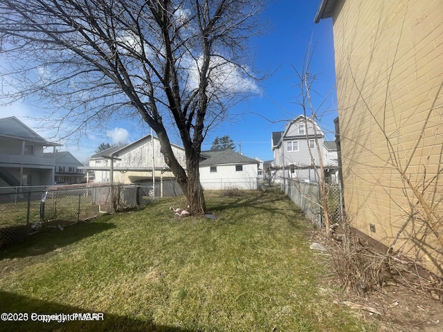 view of yard featuring a fenced backyard and a residential view