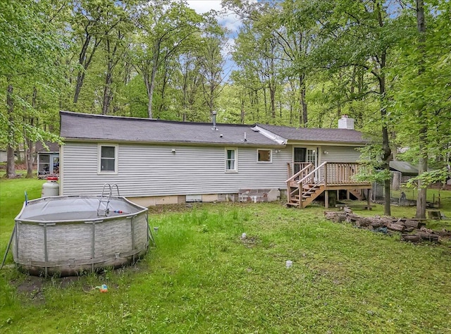 3405 Masons Ln, East Stroudsburg, PA 18302 - rear view of property with a chimney, a wooden deck, a lawn, an outdoor pool, and roof with shingles