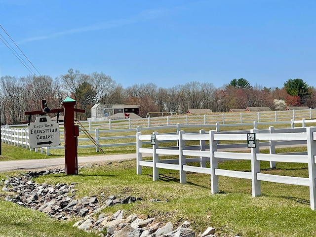 view of yard with fence and a rural view