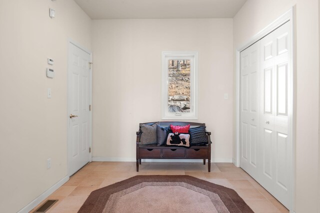interior space featuring light tile patterned floors, visible vents, and baseboards
