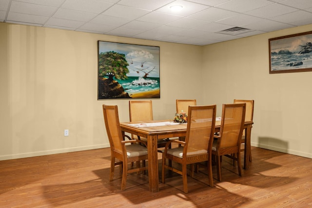 dining space featuring light wood-type flooring, visible vents, and baseboards
