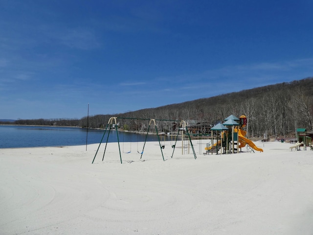 community play area with a water view and a wooded view