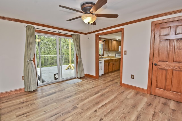 spare room featuring a sink, light wood-style floors, baseboards, a ceiling fan, and ornamental molding