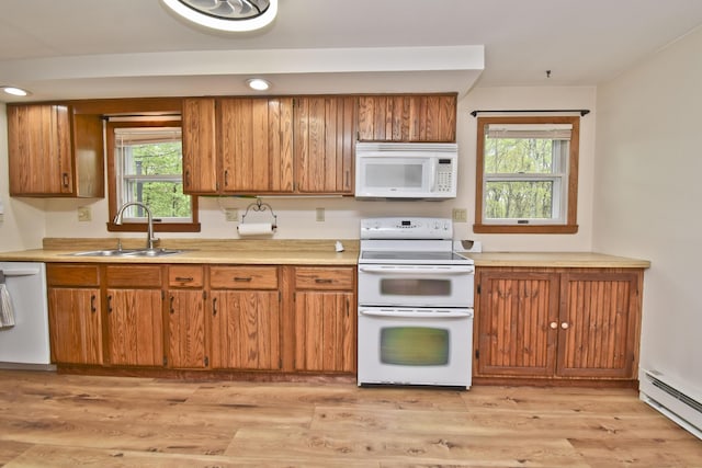 kitchen with white appliances, a sink, a baseboard radiator, brown cabinetry, and recessed lighting