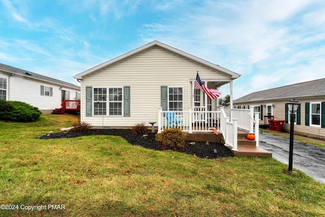 back of property with covered porch and a lawn