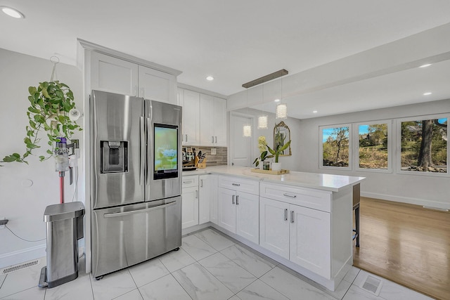 23 Primrose Dr, East Stroudsburg, PA 18302 - kitchen with a peninsula, recessed lighting, white cabinets, stainless steel fridge with ice dispenser, and hanging light fixtures