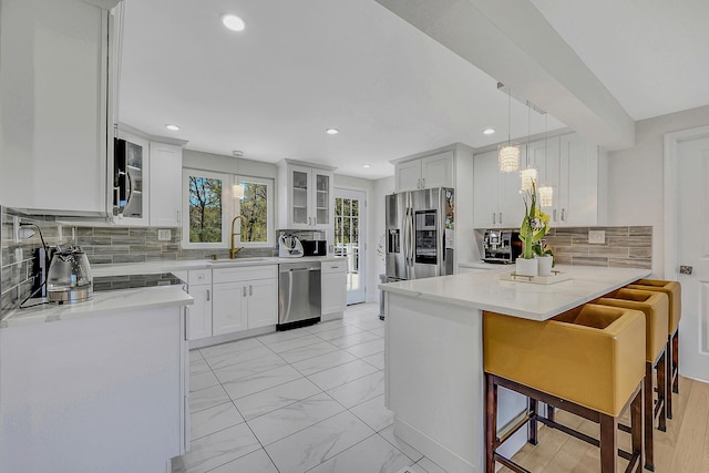 23 Primrose Dr, East Stroudsburg, PA 18302 - kitchen featuring a sink, stainless steel appliances, white cabinetry, tasteful backsplash, and glass insert cabinets