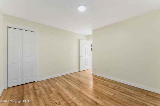 unfurnished bedroom with light hardwood / wood-style floors and a closet