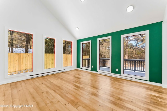 unfurnished sunroom featuring vaulted ceiling and baseboard heating