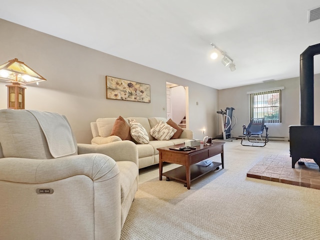 5119 Derby Rd, Tobyhanna, PA 18466 - living room featuring a wood stove, light colored carpet, stairs, and track lighting